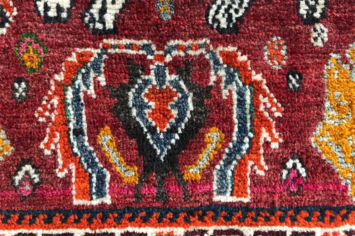 Carpet detail with a stylized white animal figure and red and blue ornaments