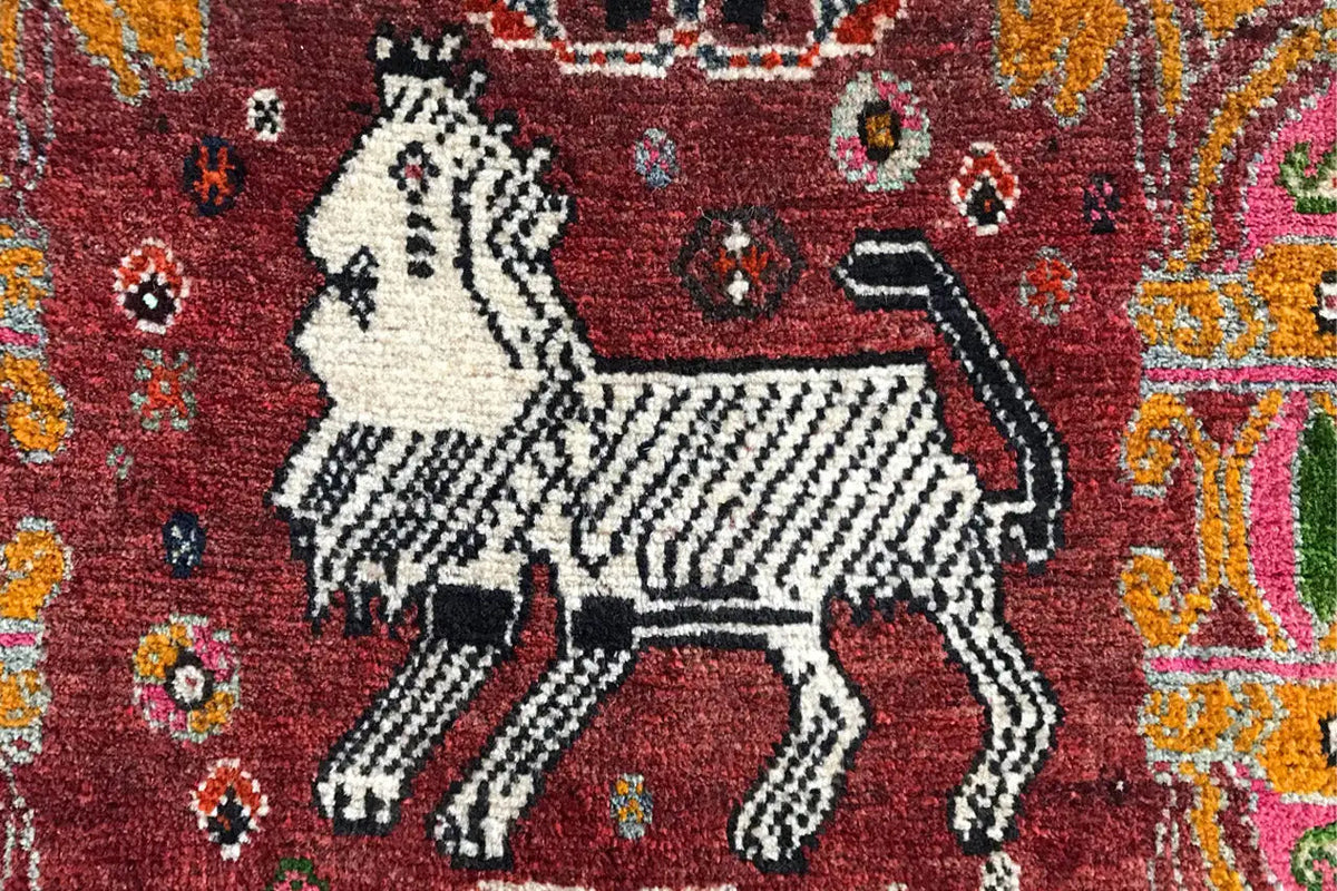 Rug detail: white horse with black outline on a red background