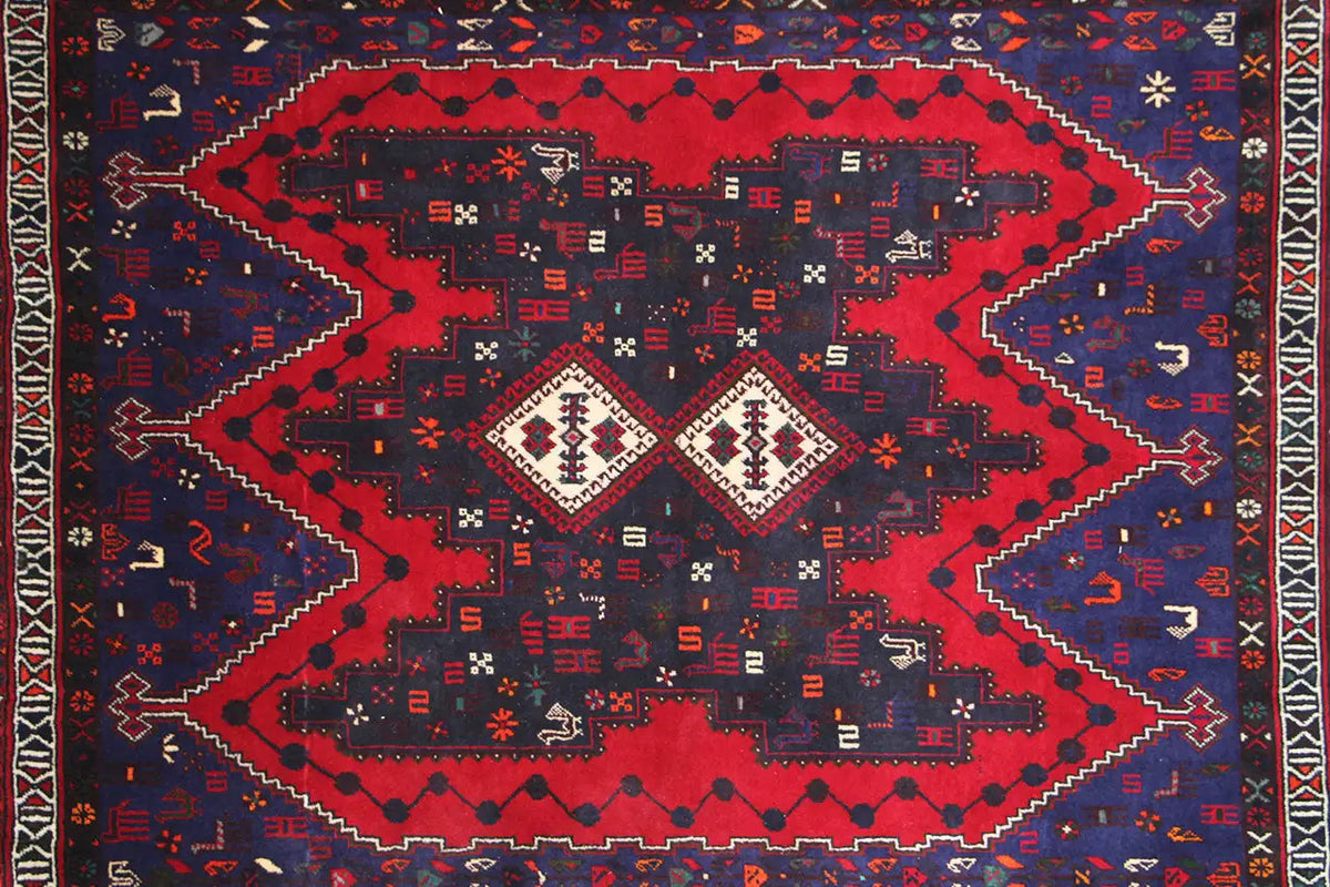 Rug surface with a large red central motif and geometric patterns in blue