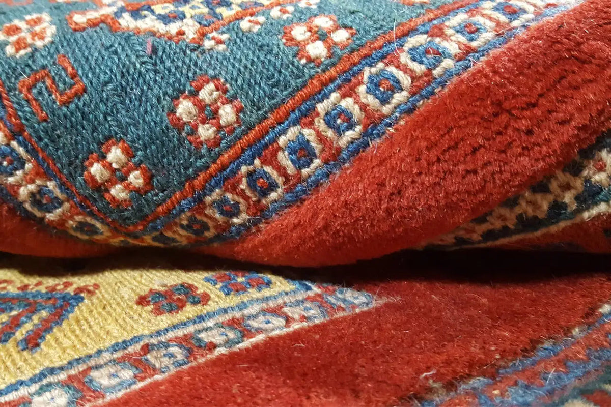 Carpet detail with red pile and blue-turquoise and beige decorative elements