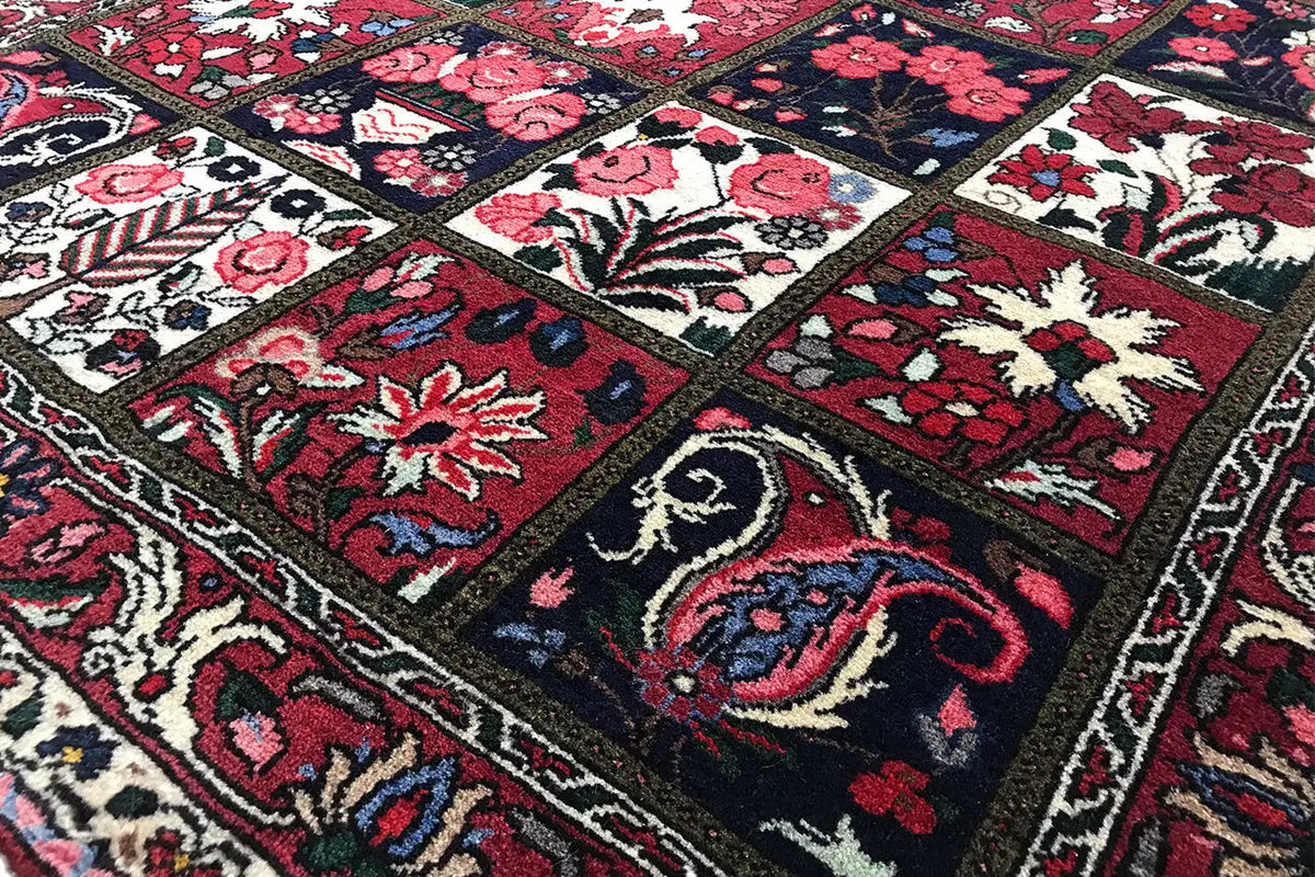 Oriental rug with geometric border panels and floral patterns in red and dark blue