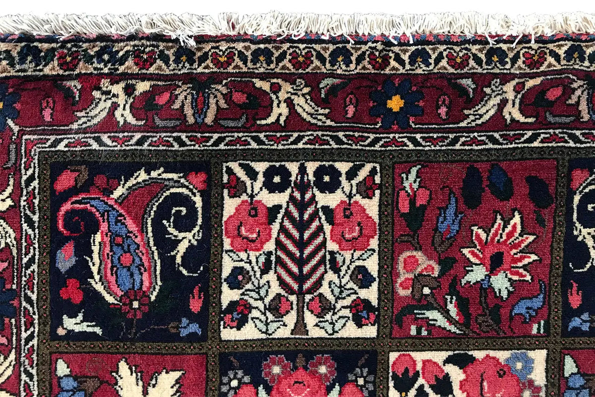 Close-up of an Oriental rug: border stripes and floral motifs in red and blue