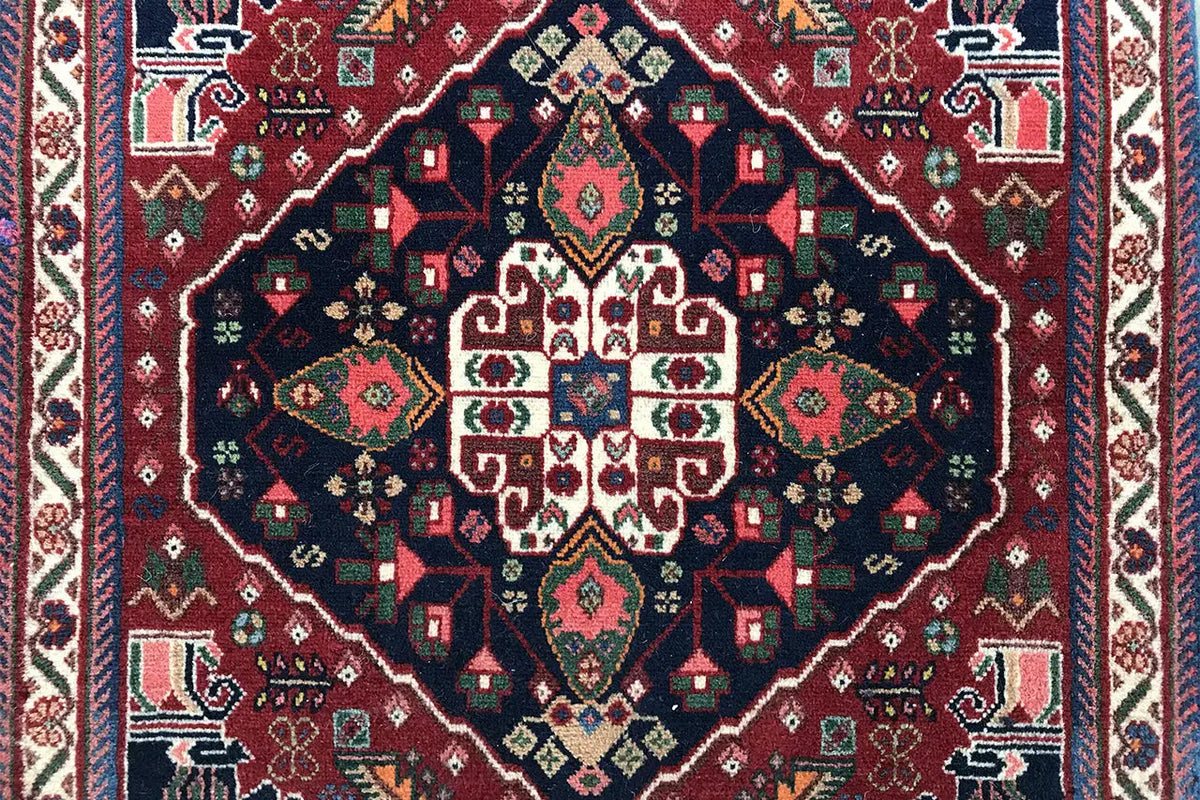 Detail view: carpet pattern with a symmetrical medallion in blue, red, green, and beige