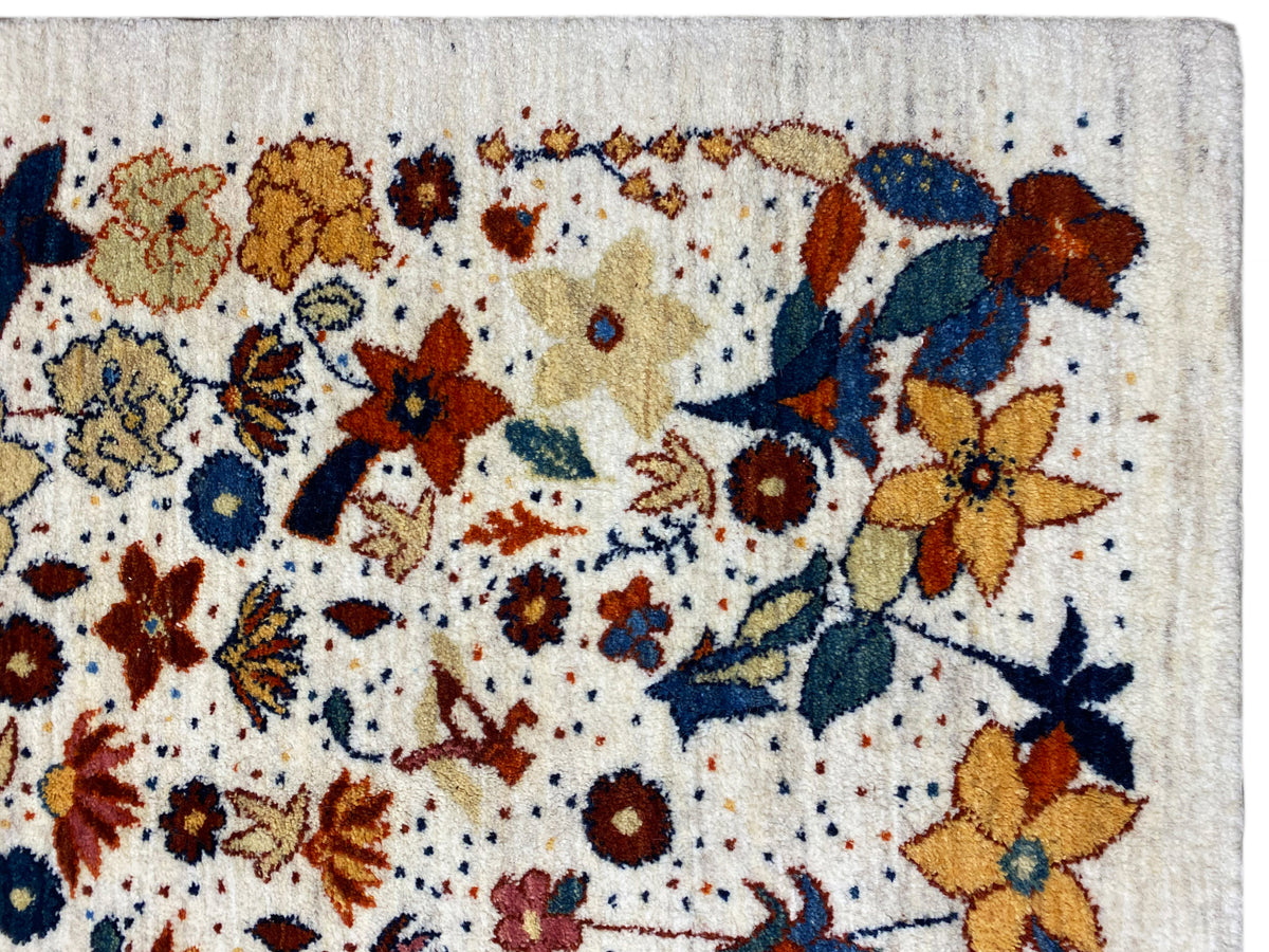 Nahaufnahme Teppichoberfläche mit mehrfarbigen Blumen und feiner Webstruktur auf hellem Grund