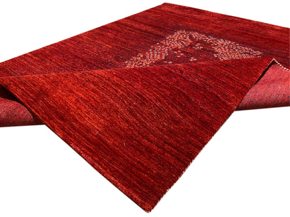 Roter Teppich mit hochgeklappter Kante und Medaillon-Motiv, seitliche Ansicht