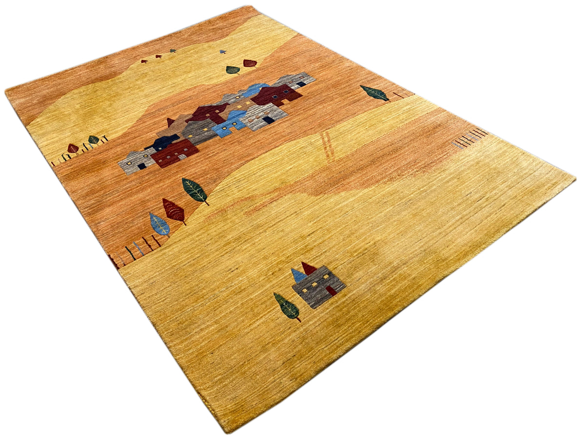 Teppich mit hellem Grund und zentralem Dorfmotiv in Blau und Rot, von schmalem Rahmen