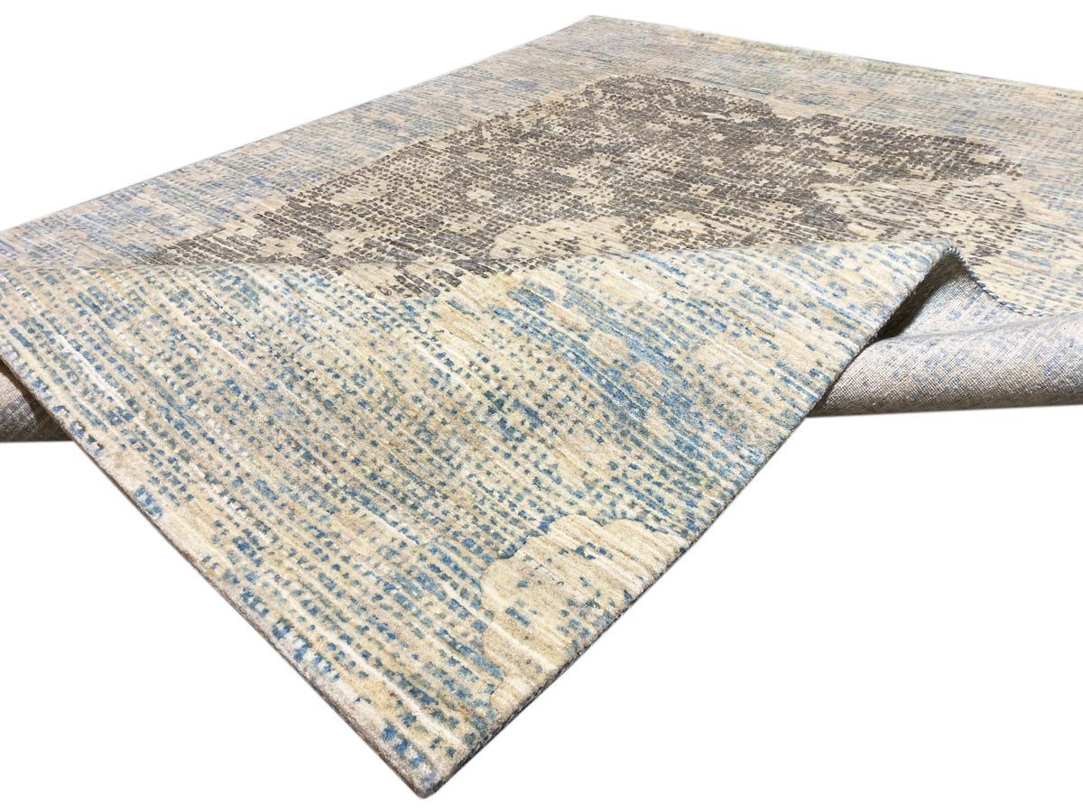 Teppich in Blau-Grau mit diagonaler Musterfläche und leicht gesäumter Kante