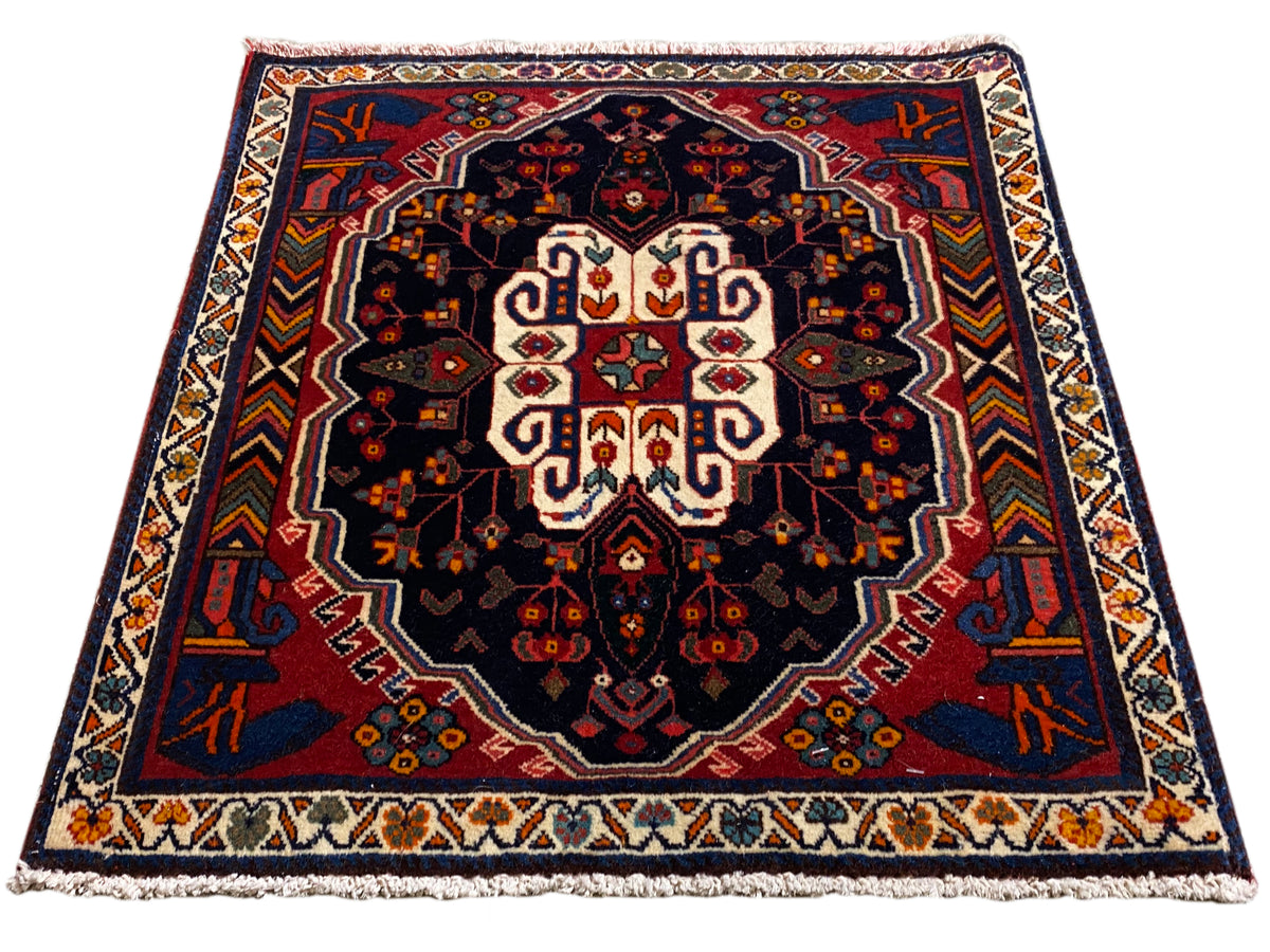 Poshti rectangular rug with a blue background and symmetrical ornamental pattern