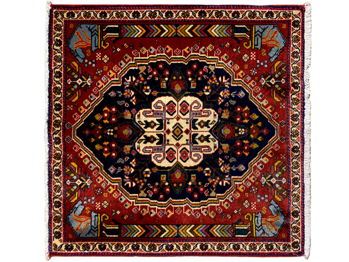 Poshti rug with a red ground, dark medallion, and multicolored border ornaments
