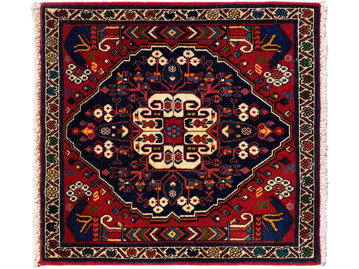 Rug with a square medallion, blue-red pattern, cream-colored accents, and fringed edge