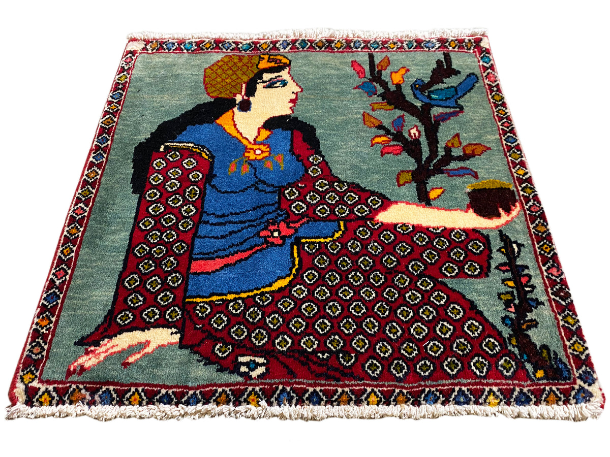 Poshti rug 68x63 cm in three-quarter view with figure, tree, red patterned borders, and fringes