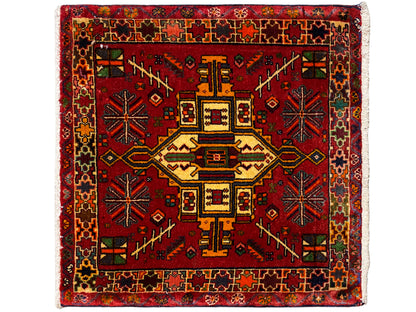 Rectangular Poshti rug with a red background and a multicolored geometric central motif