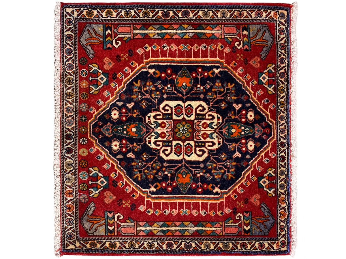 Rug with a red background, dark blue medallion, and multicolored border, square