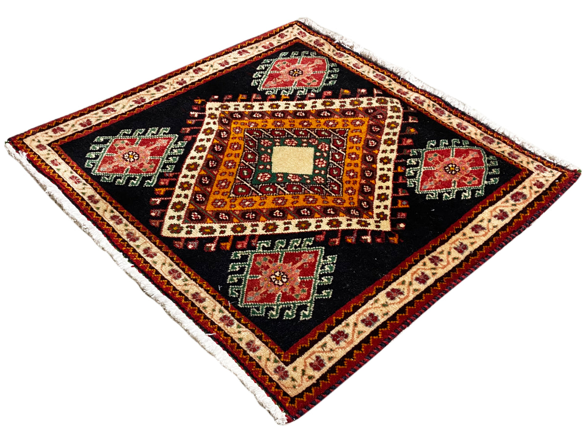 Poshti rug with diamond angles, a black background, a central white diamond, and a colorful border