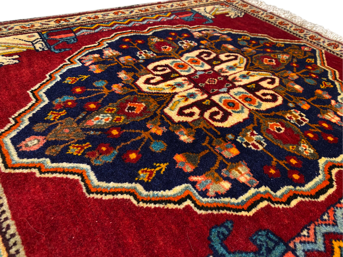 Close-up of the center of the rug: dark blue, red, beige, and multicolored ornamental areas