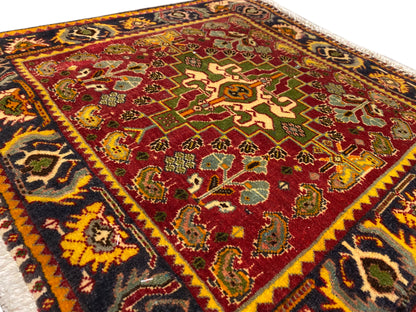 Carpet surface with a red central motif, green ornaments, and a colorful decorative border