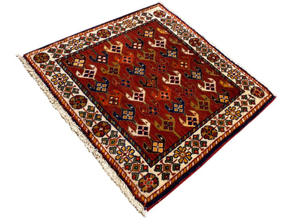 Rug 61x61 cm with a red patterned field, multicolored border, and frayed edges