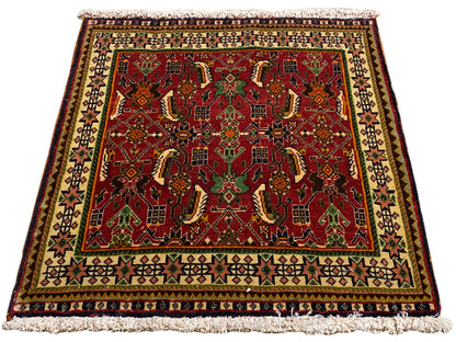 Poshti rug 63x61 cm, angled view: red ornamental pattern in green and beige.