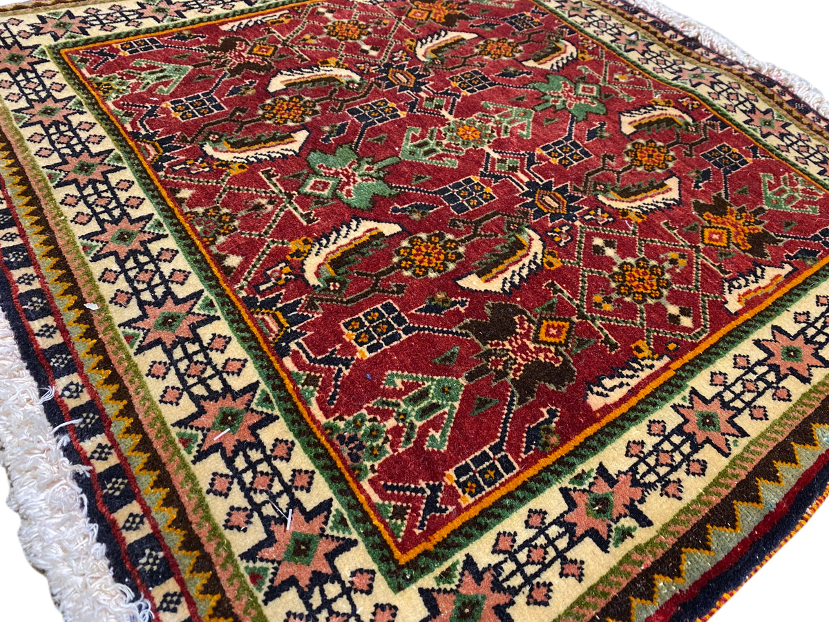 Poshti rug 63x61 cm close-up: red pattern with animal/ornamental motifs and border.