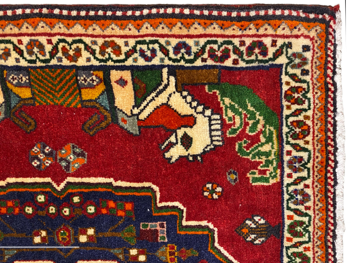 Close-up of a Poshti rug, red field with animals, blue decorative edge and patterned border