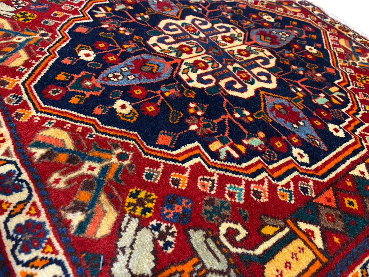 Close-up of a rug: blue pattern with red and yellow ornaments, woven texture