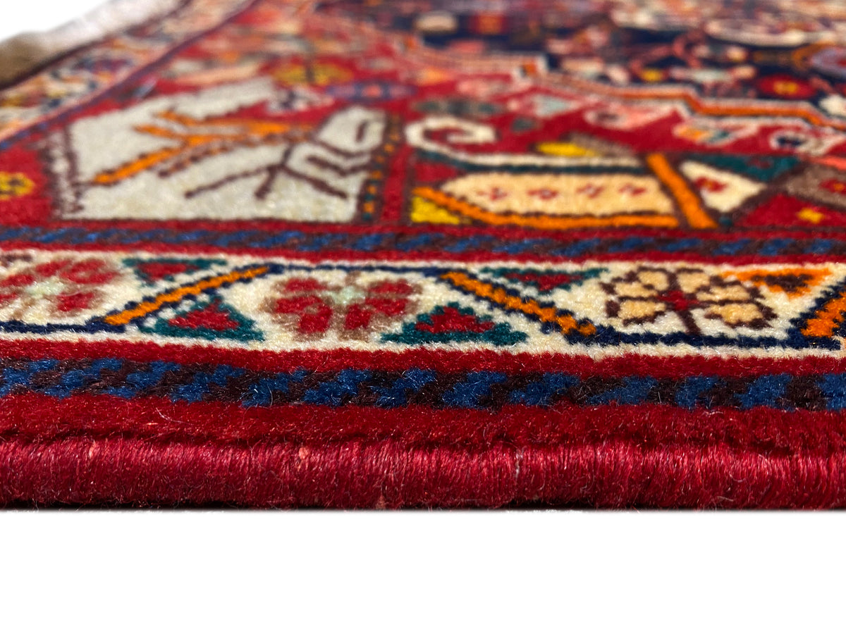 Carpet detail at the edge: red-and-blue border, multicolored patterns, and short fringes