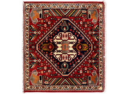 Oriental rug with a red background, dark blue medallion, and geometric ornaments