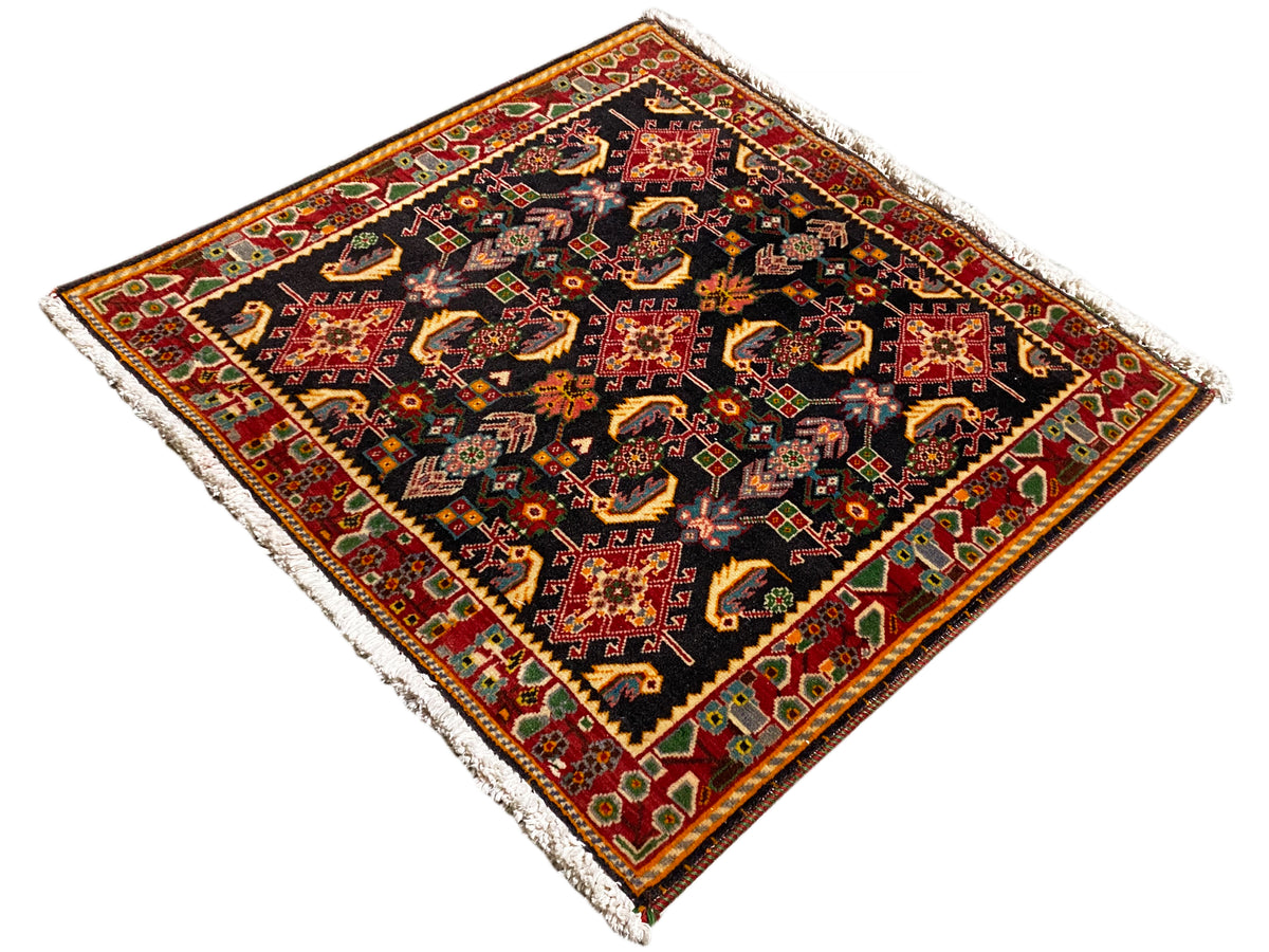 Rug with an ornamental central motif, black, red and yellow tones, green accents