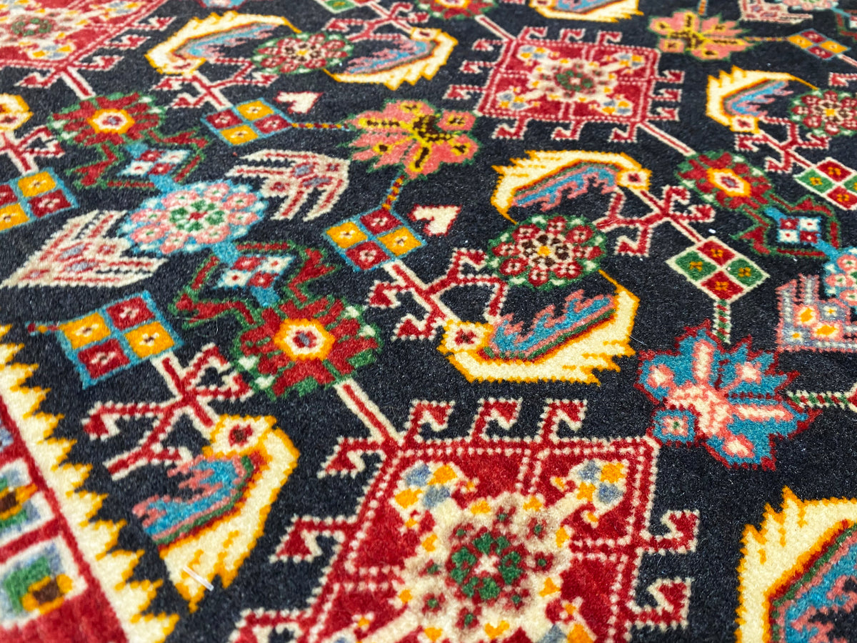 Rug surface with a colorful geometric pattern in black, red, green, and yellow