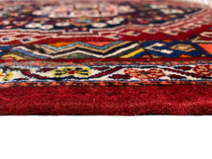 Carpet detail with a colorful pattern and a high red pile along the edge