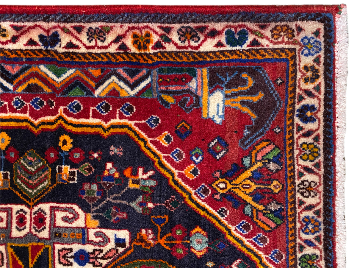 Carpet edge with decorative border, red-and-blue pattern, and white fringes, close-up view