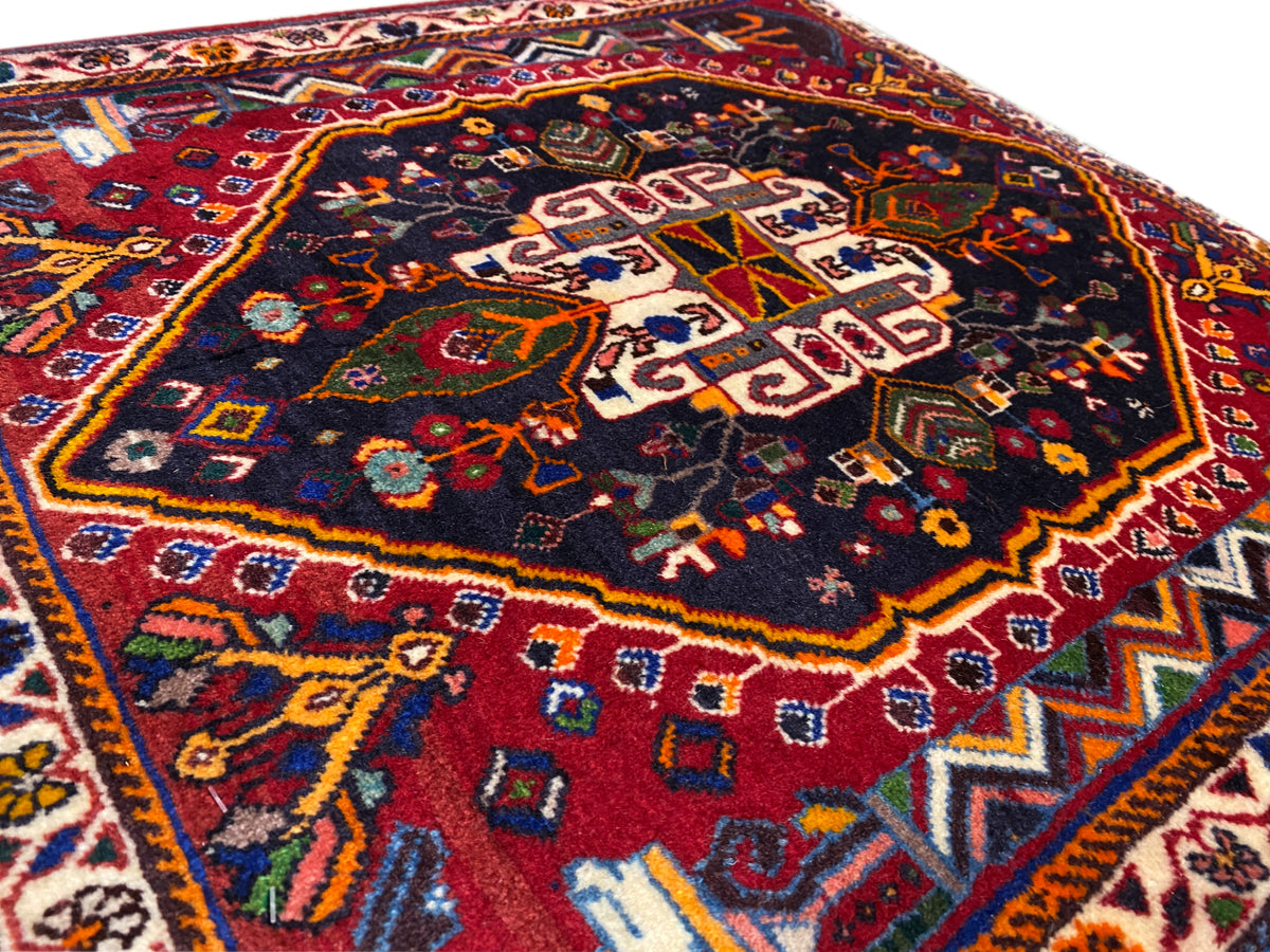 Close-up of the carpet surface with a geometric pattern in blue, red, and gold
