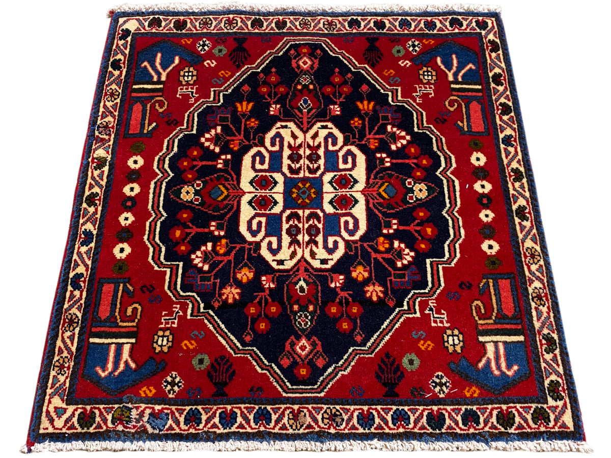 Square rug with a red border and dark field, stylized central ornament