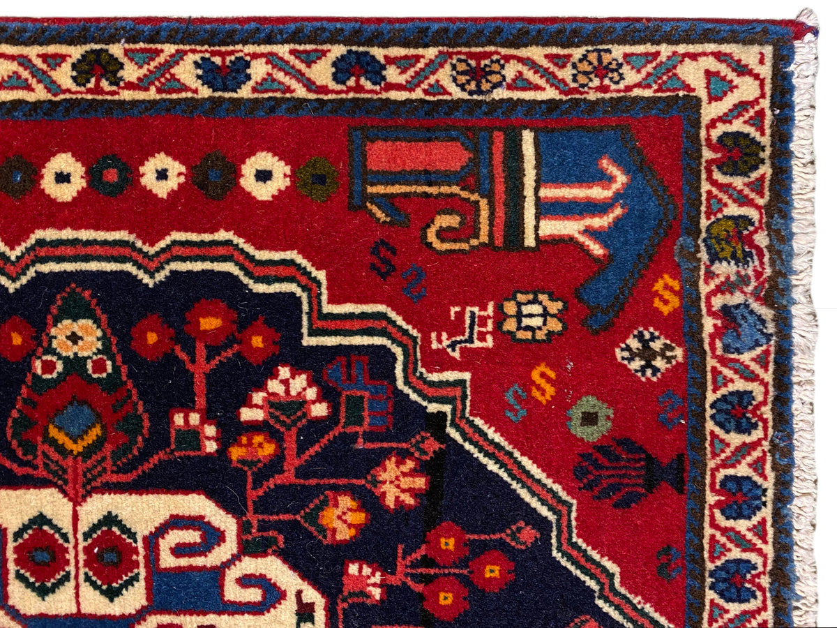 Carpet corner with a red background, colorful symbols, and a blue decorative border