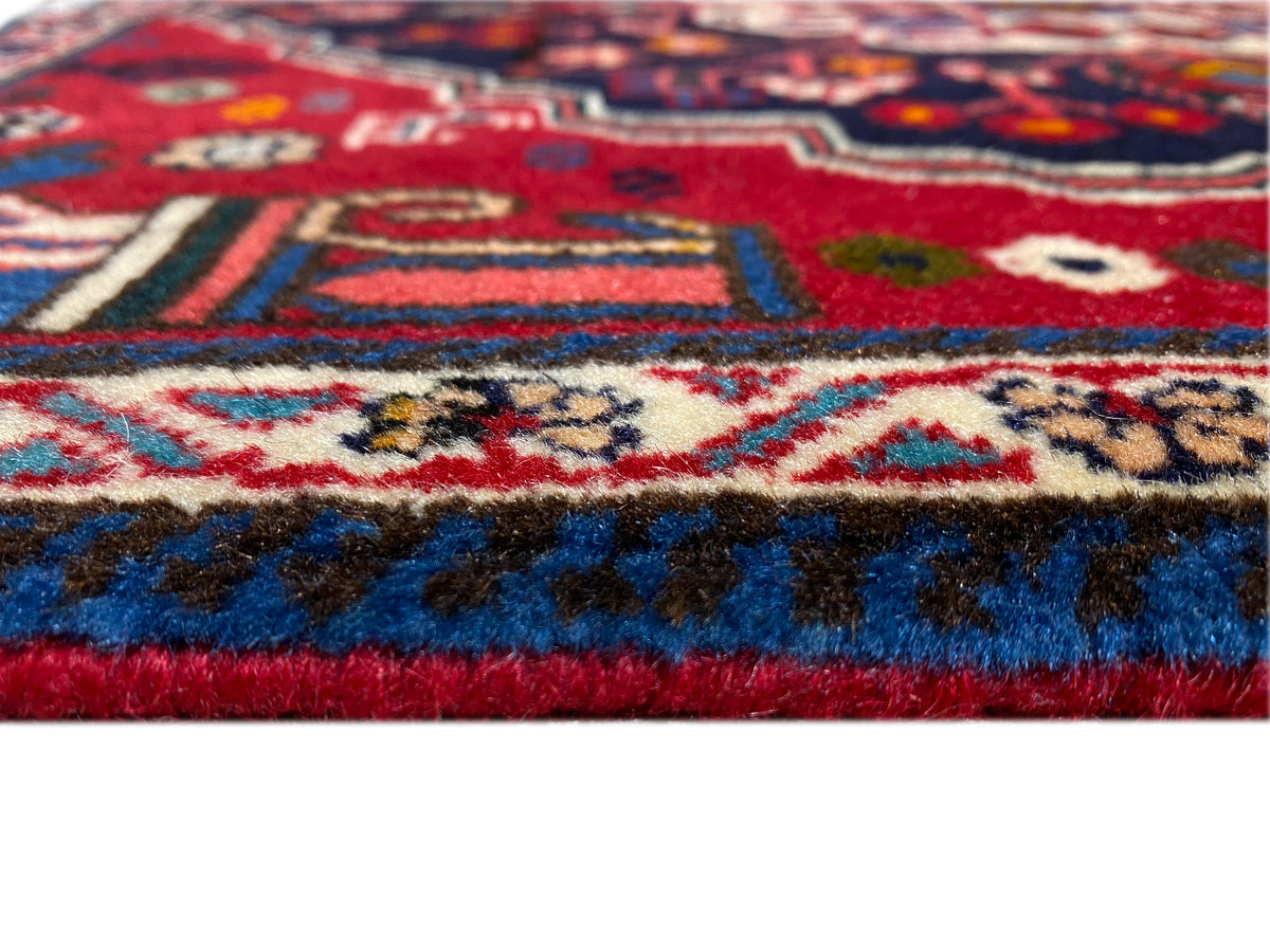 Rug edge with short pile, red lower edge, and blue-and-white pattern