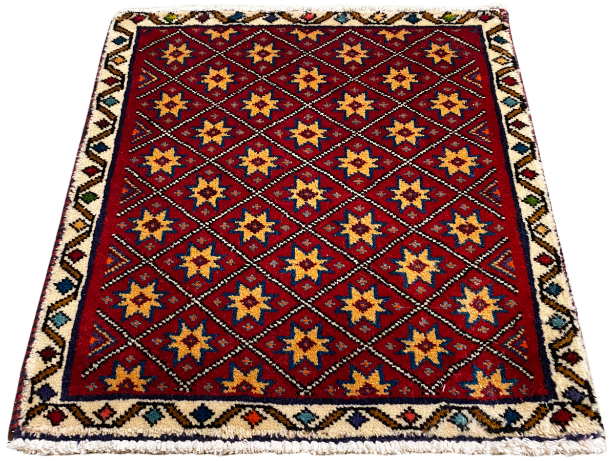 Square rug with a red background and gold, blue, and black stars